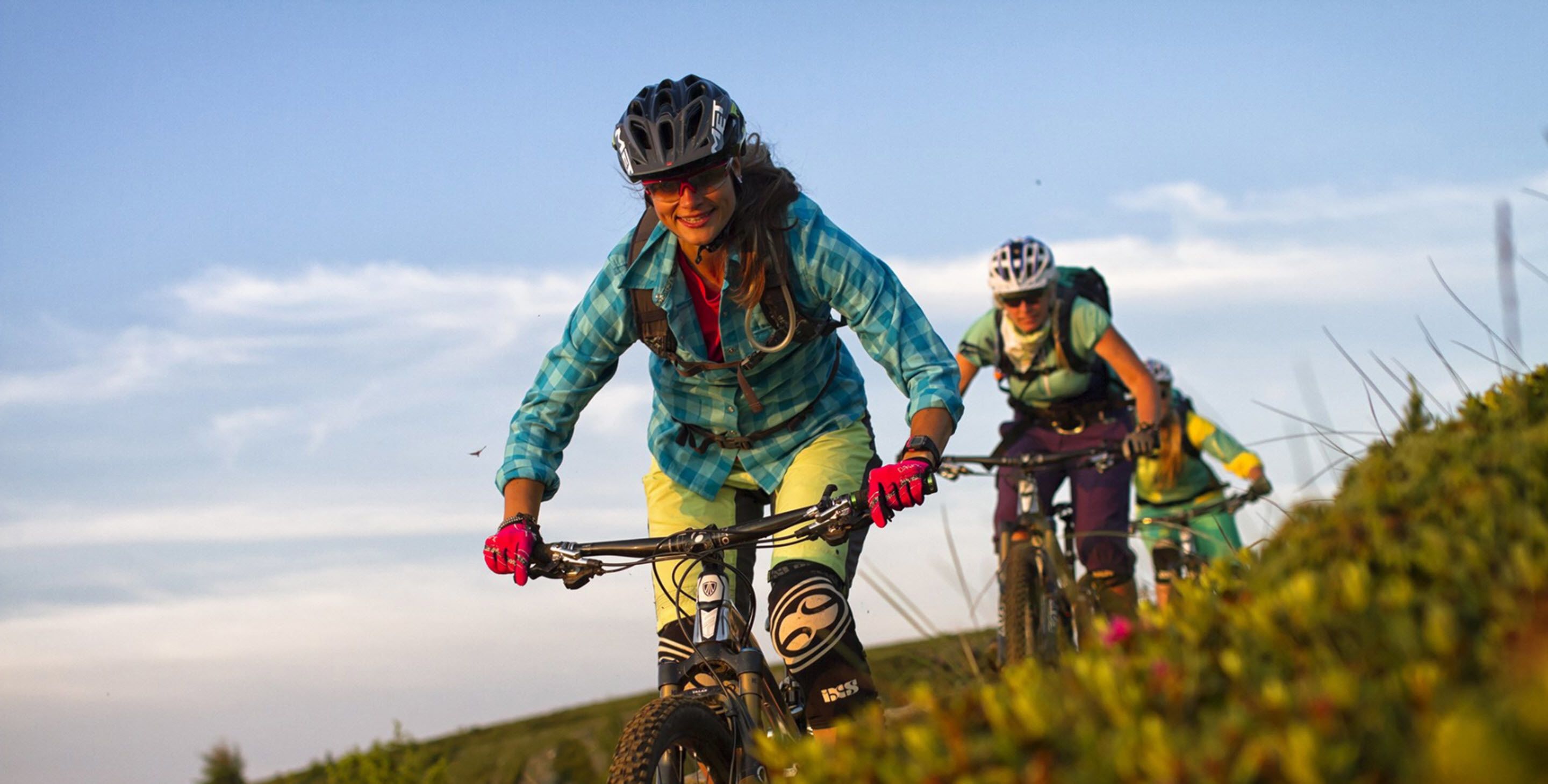Dois ciclistas numa trilha sob um céu claro.