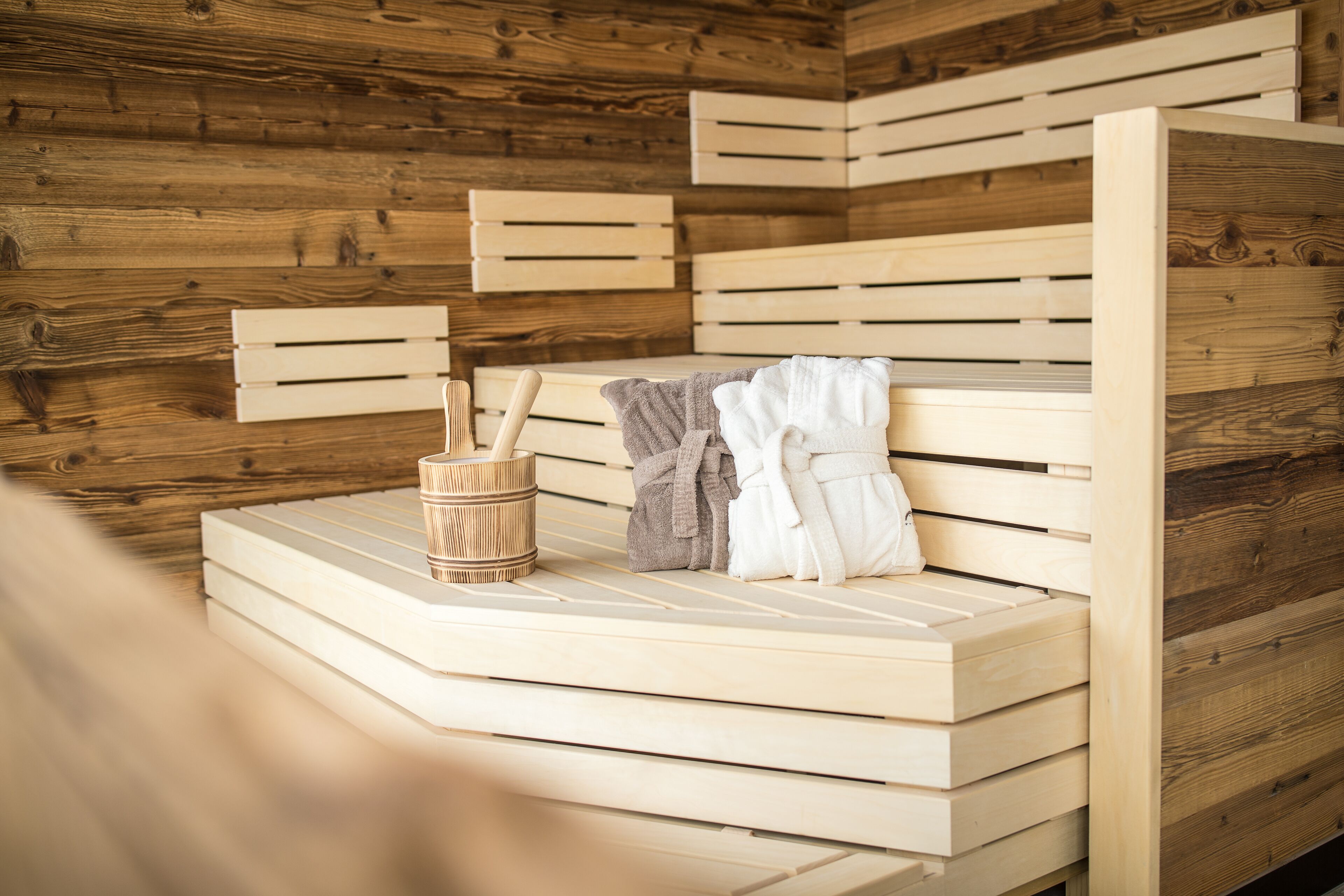 A wooden sauna with benches and a wooden wall.
