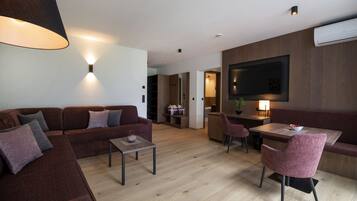 Un salon moderne comprenant un canapé, une table basse et un coin repas avec une table et des chaises.