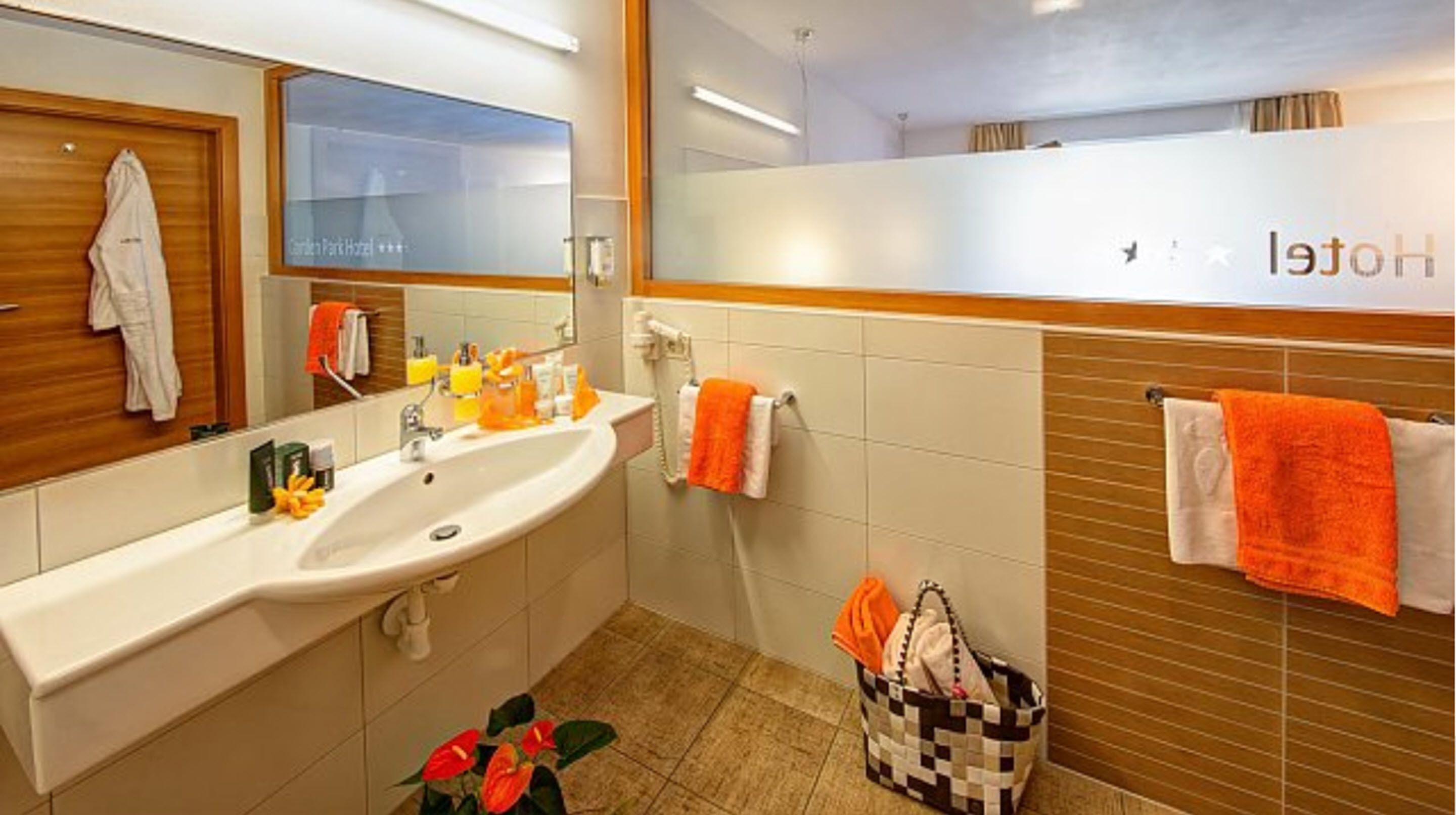 A hotel bathroom with a sink, mirror, and towel rack.