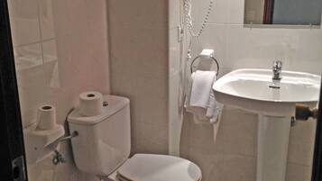 Un baño con inodoro, bidé y lavabo.