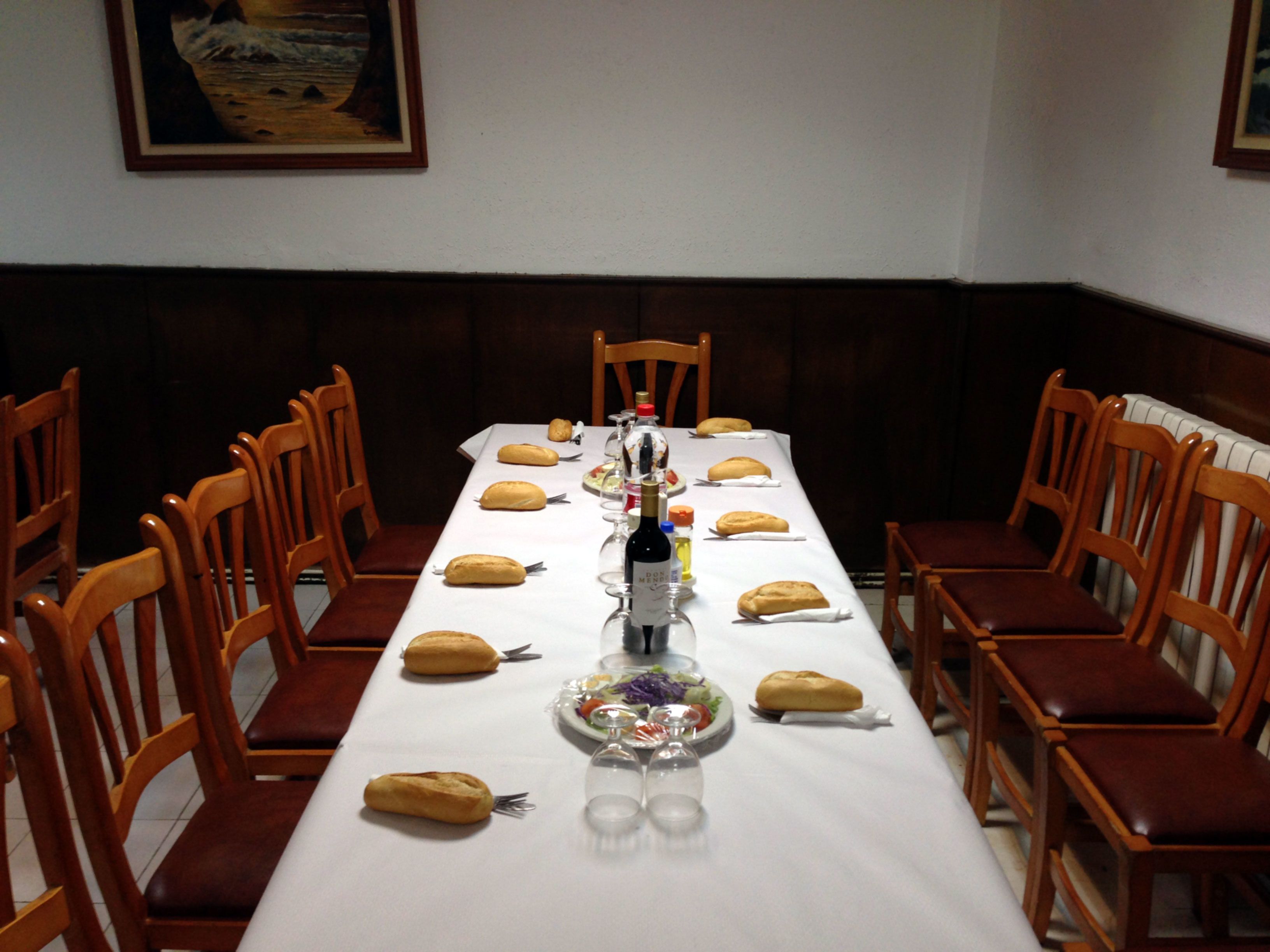 Ein Esstisch ist für eine Mahlzeit gedeckt, mit Stühlen darum herum.