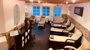 Un cuarto de spa con sillones de masaje, un mostrador de recepción y un espejo instalado en la pared.