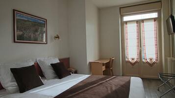 Ein Hotelzimmer mit einem Bett, einem Schreibtisch und einem Stuhl.