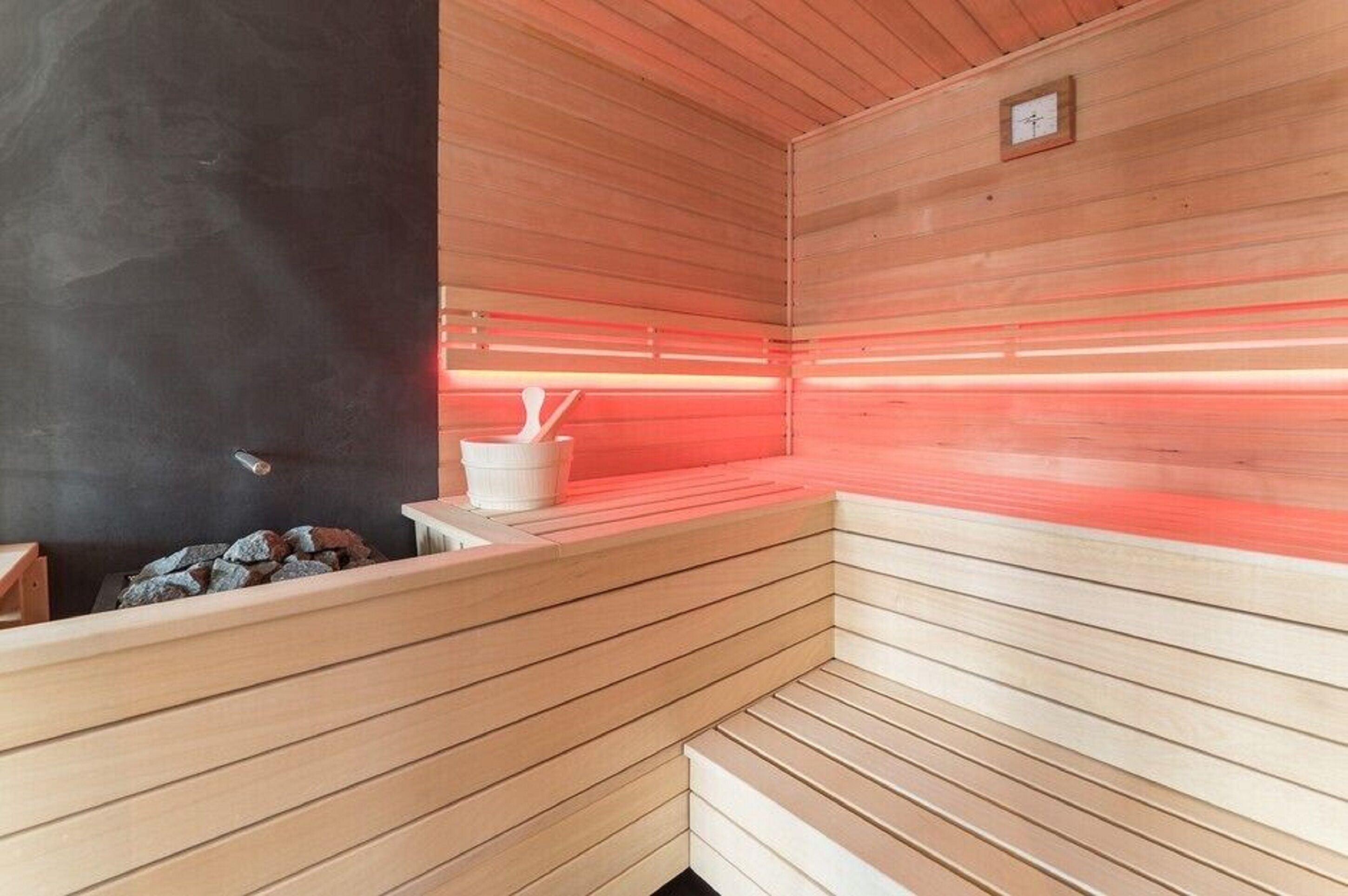 A sauna with wooden benches and a stone bench.