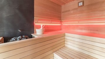 A sauna with wooden benches and a stone bench.