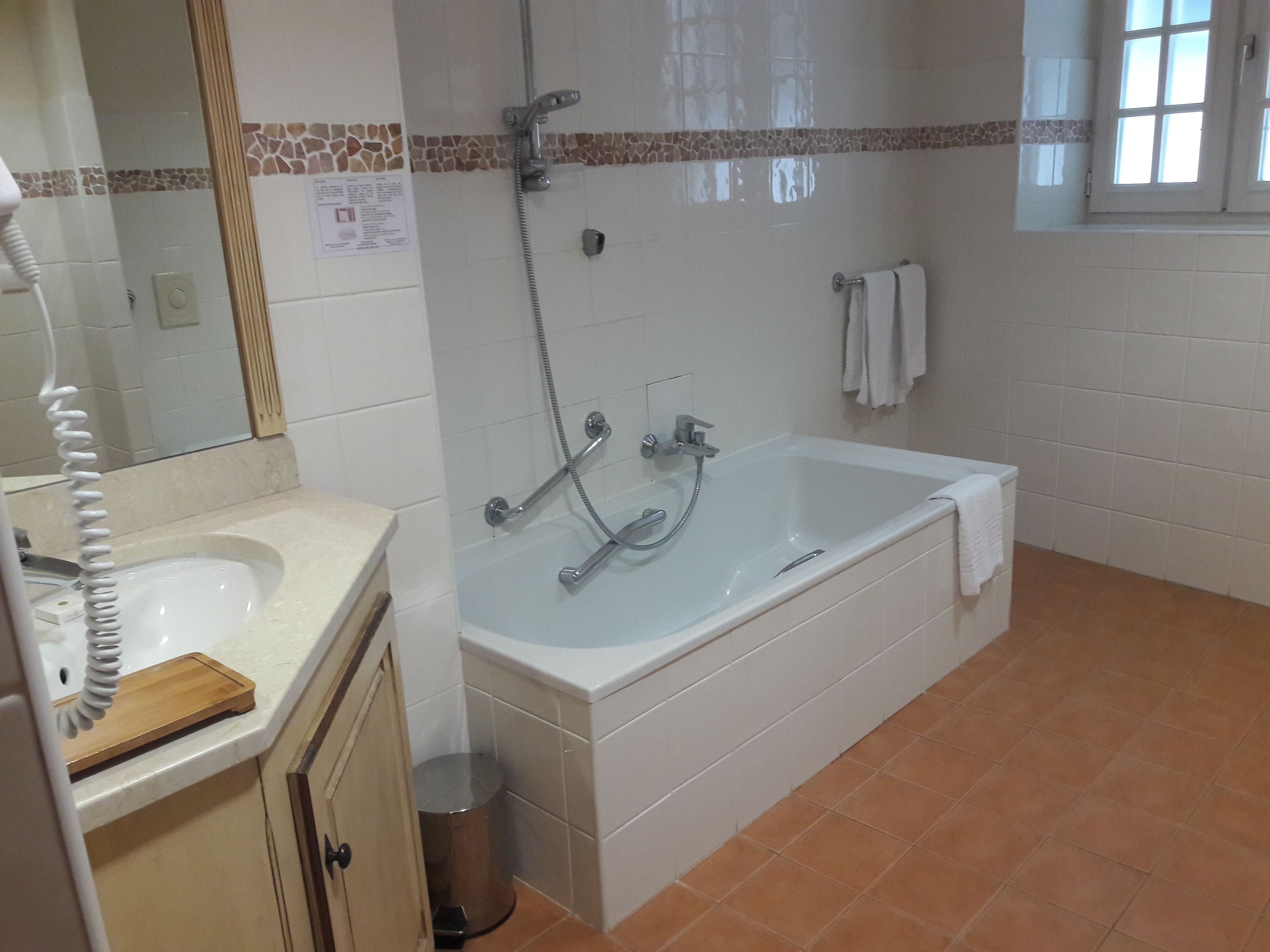 Un baño con bañera, lavamanos e inodoro.