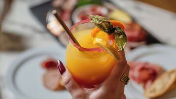 A hand holding a cocktail with a lemon twist garnish.