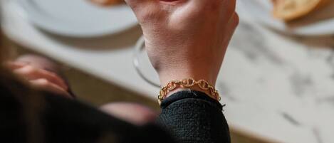 A hand holding a cocktail with a lemon twist garnish.