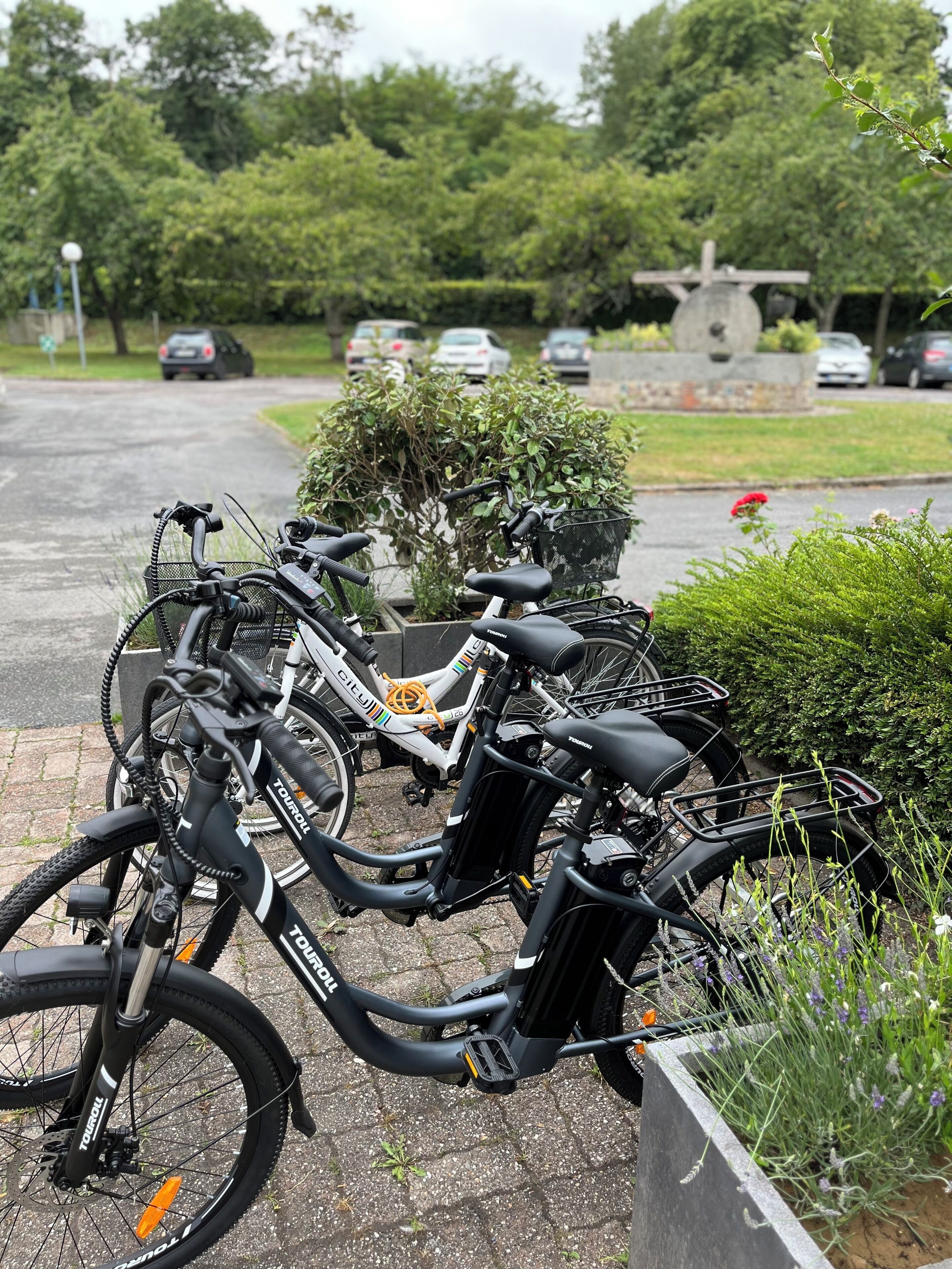 Bicicletas estacionadas en un área designada, con un monumento de piedra al fondo.