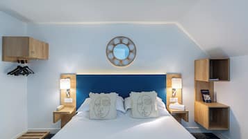 Quarto de hotel moderno com uma cama grande, duas mesas de cabeceira com luminárias, um painel de cabeceira em madeira, um espelho fixado na parede e prateleiras embutidas.