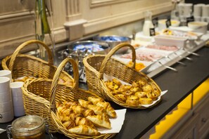 A buffet with baskets of pastries and a variety of food items. - Hotel Restaurant Du Lac de Madine (Heudicourt-Sous-les-Cotes)