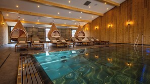A modern indoor swimming pool with clear water, wooden walls, and lounge chairs. - Hotel Restaurant Du Lac de Madine (Heudicourt-Sous-les-Cotes)