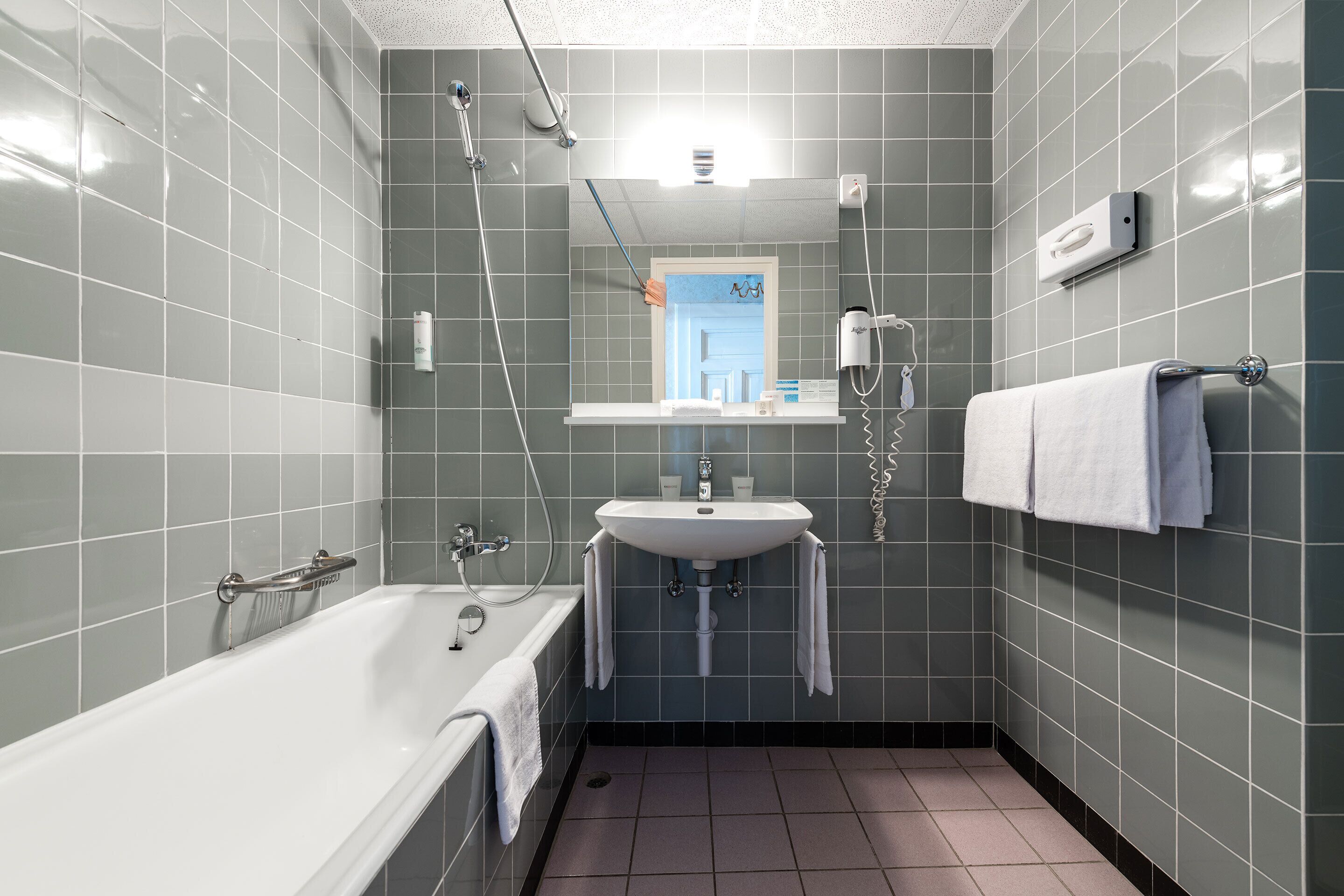 A modern bathroom with a bathtub, a sink, and a shower.