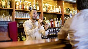 A bar with shelves stocked with various liquor bottles and glasses.