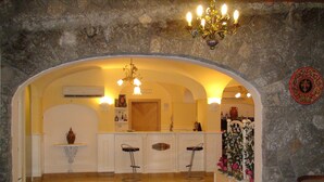 Amplia sala de estar con cocina, bar y pared de piedra.