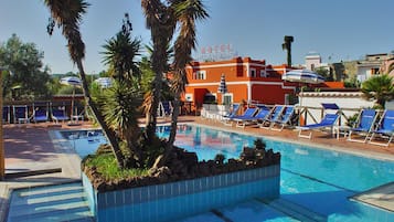Una piscina al aire libre de temporada, sombrillas