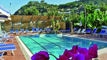 Una piscina al aire libre de temporada, sombrillas