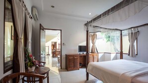 Une chambre avec un grand lit, des meubles en bois, une télévision et une vue sur l’extérieur.