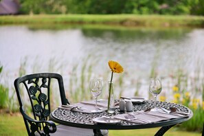 A dining table set outdoors with a view of a lake. - Walkersons Hotel & Spa (Dullstroom)