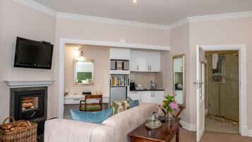 A living room with a fireplace, television, and a dining area with a table and chairs.