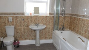 Un baño con inodoro, lavamanos y bañera.