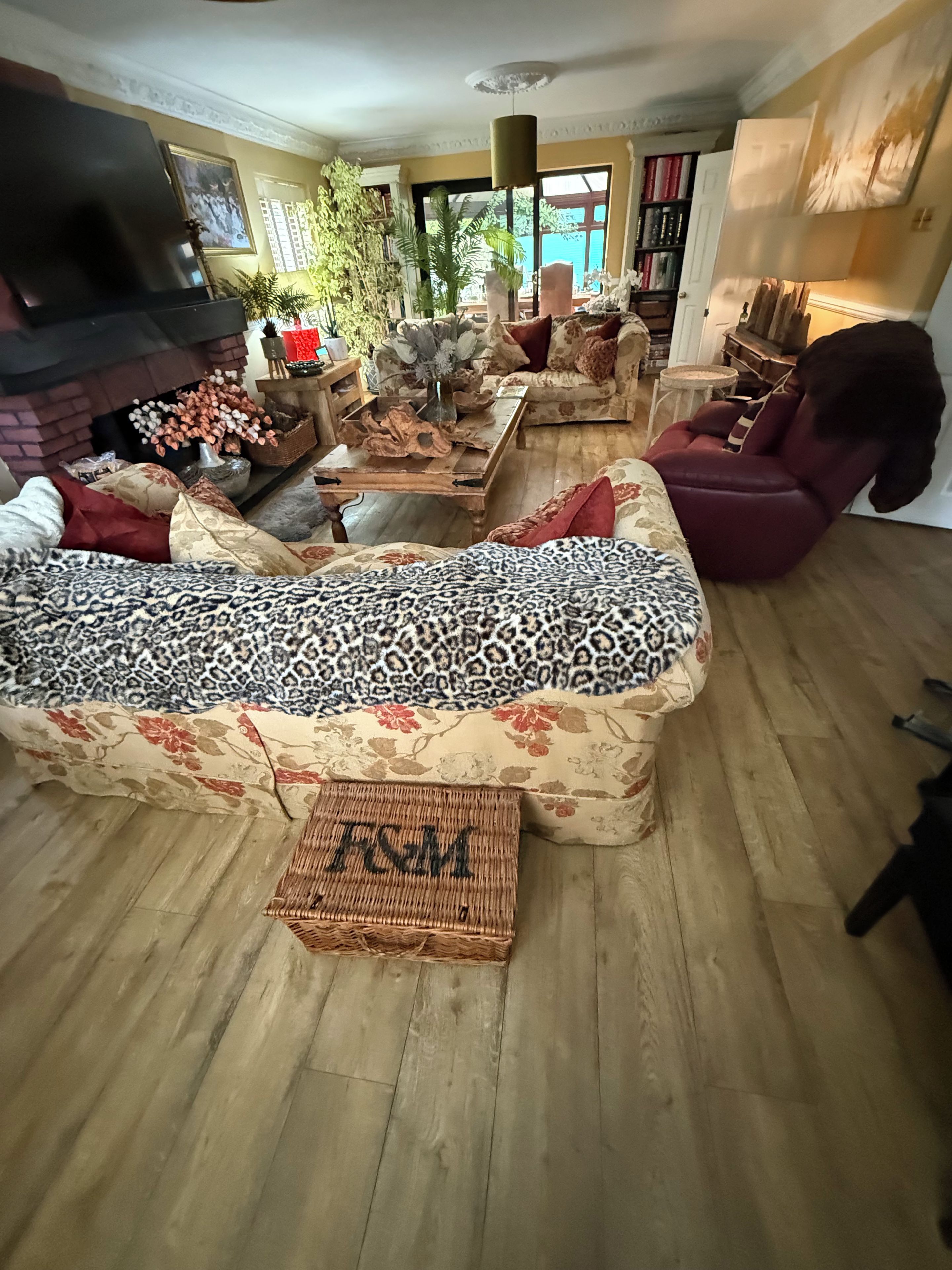 Una sala de estar con sofá, chimenea, estantería y un ventanal grande.