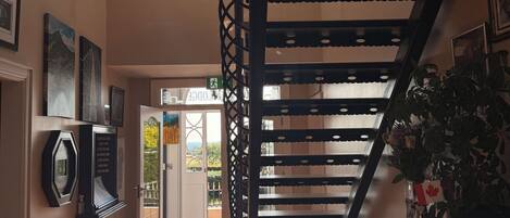 A modern interior with a staircase, a seating area with a table, and a door leading outside.