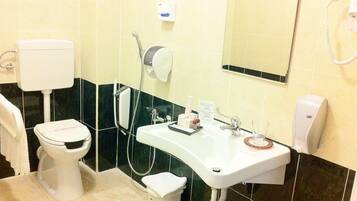 A bathroom with a toilet, sink, and shower.
