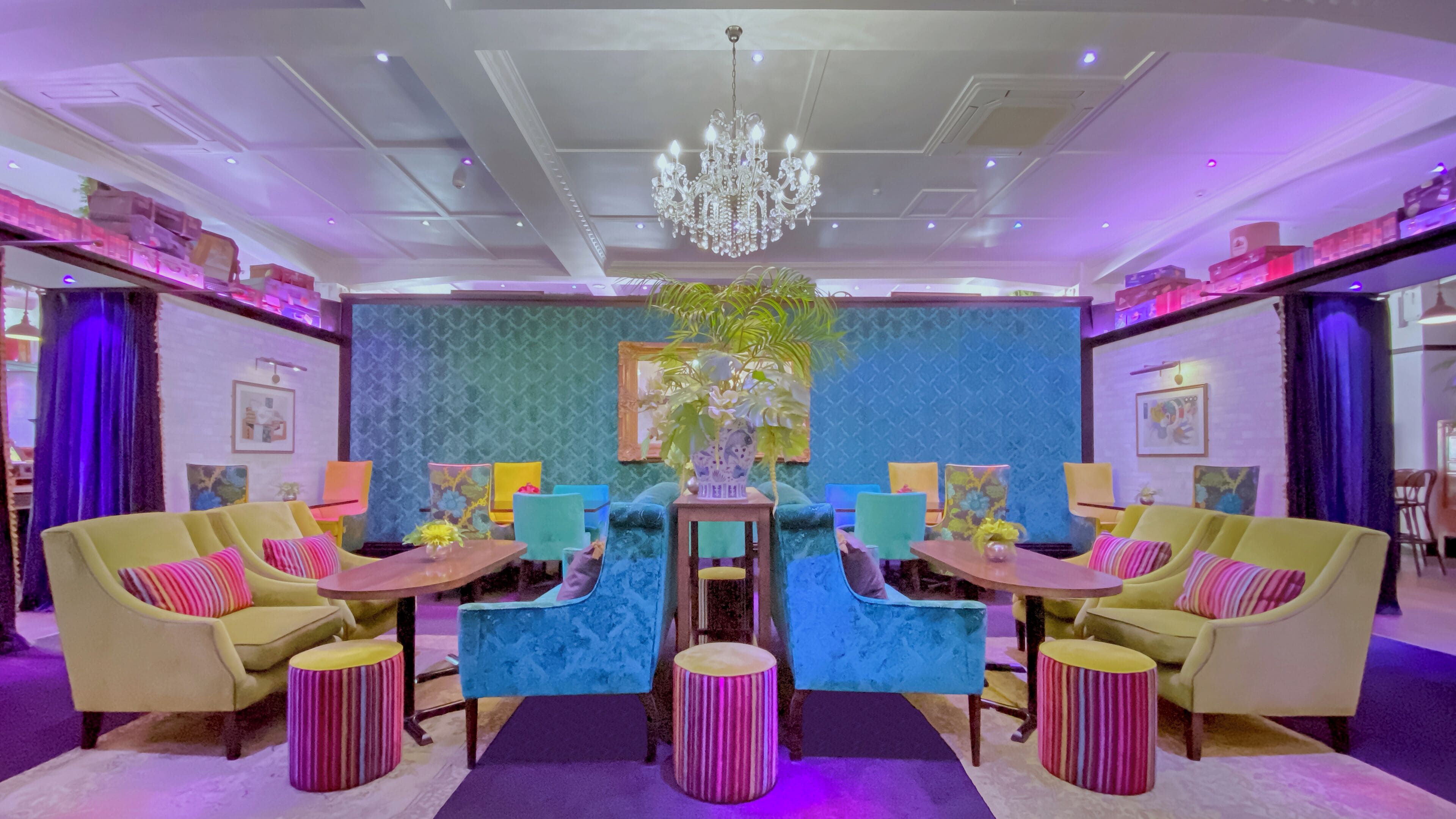 A room with a central table, two sofas, and a chandelier.