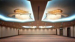 A spacious conference room with a patterned carpet, recessed lighting, and two large chandeliers. - Rihga Royal Hotel Niihama (Niihama)