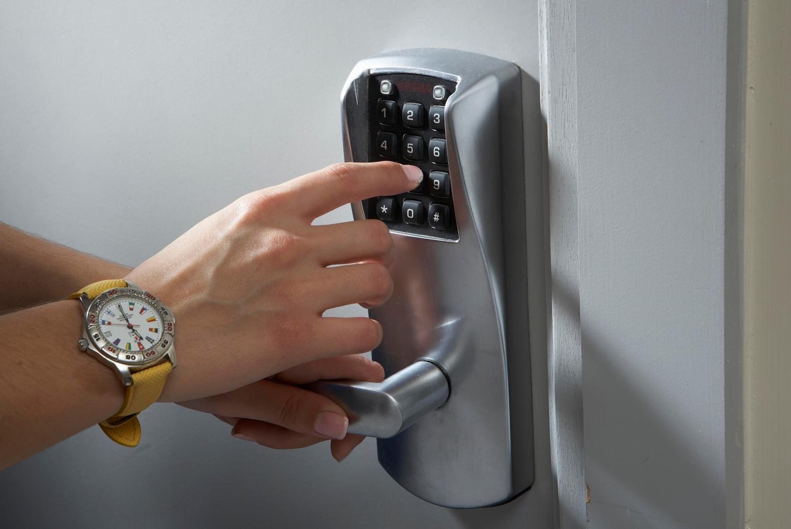 A person using a keypad lock on a door.