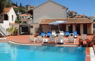 Una piscina con lettini e una zona relax all'ombra.
