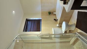 Un baño moderno con inodoro, lavabo y zona de ducha.