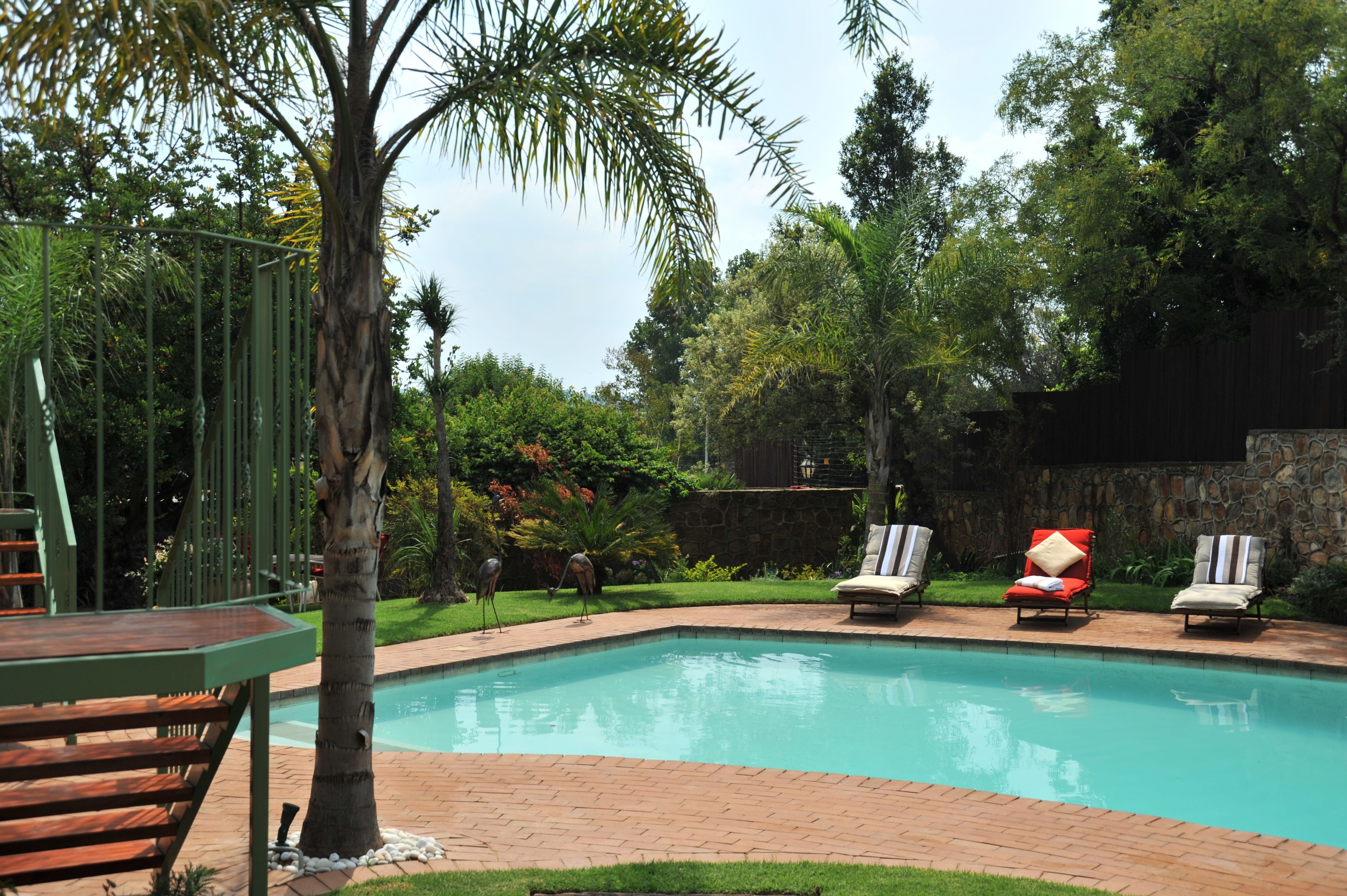 A swimming pool with lounge chairs and a wooden deck.