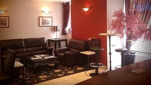 A living room with a sofa, armchairs, a coffee table, and a small side table. - Hôtel de la Basilique (Epinal)