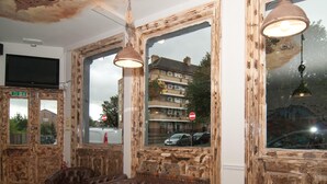 Una habitación con ventanas amplias, un sofá de cuero marrón y una pequeña mesa.