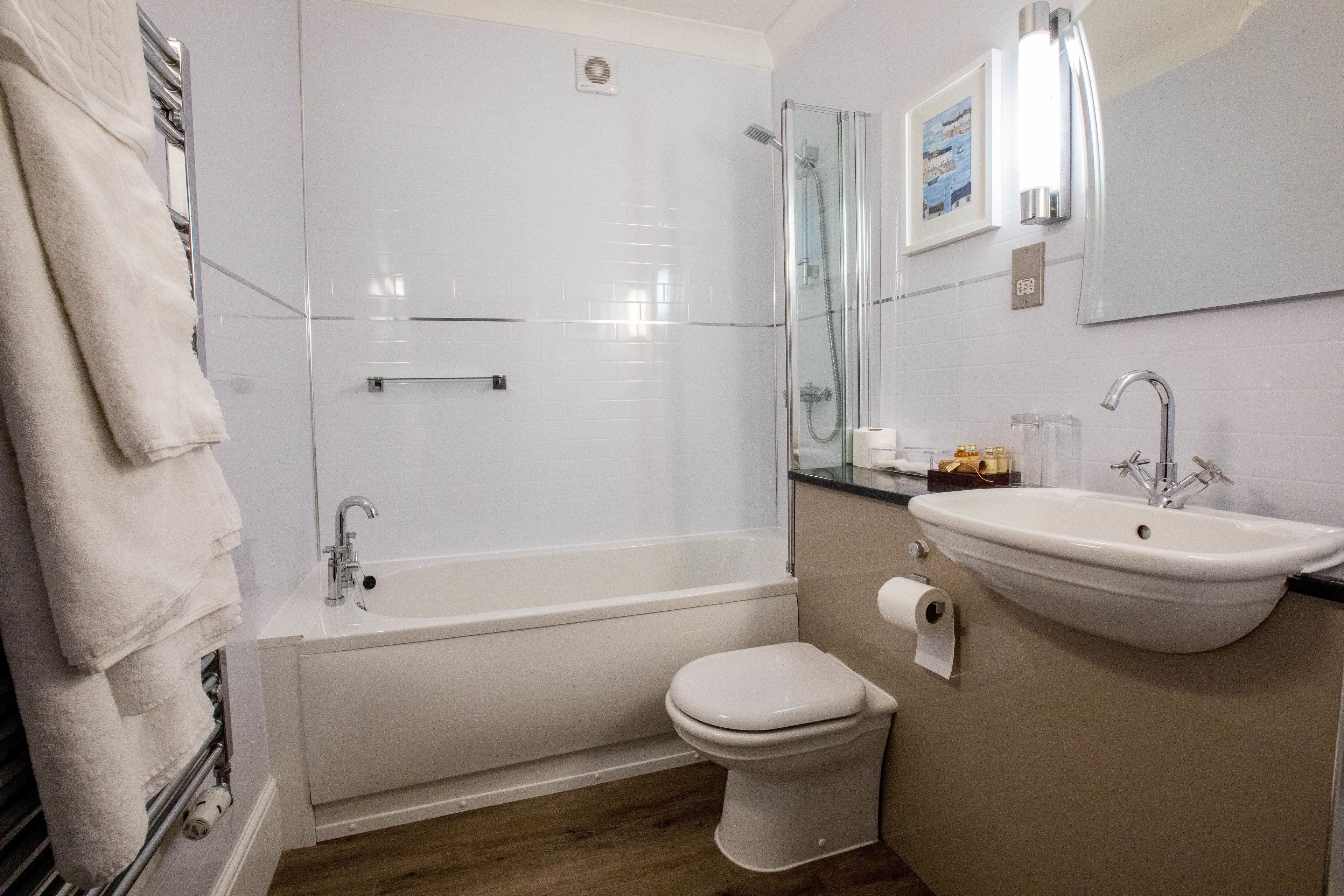 A bathroom with a bathtub, toilet, and sink.