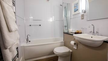 A bathroom with a bathtub, toilet, and sink.