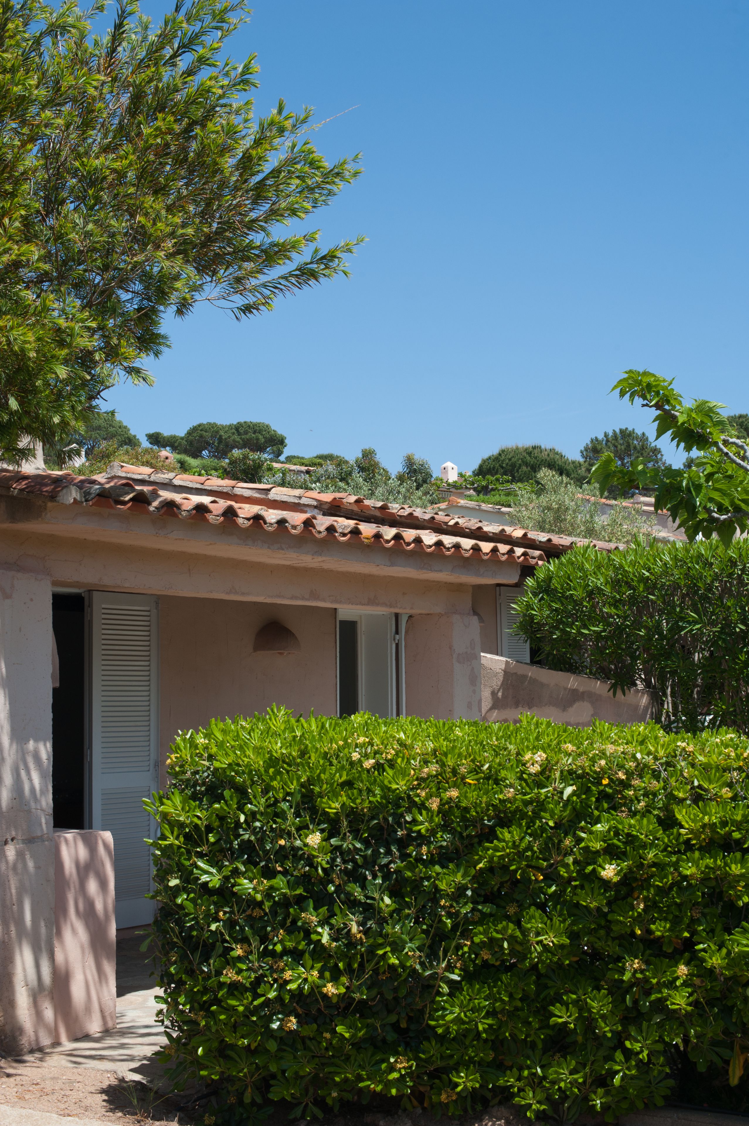 A small building with a tiled roof, a door, and a window.