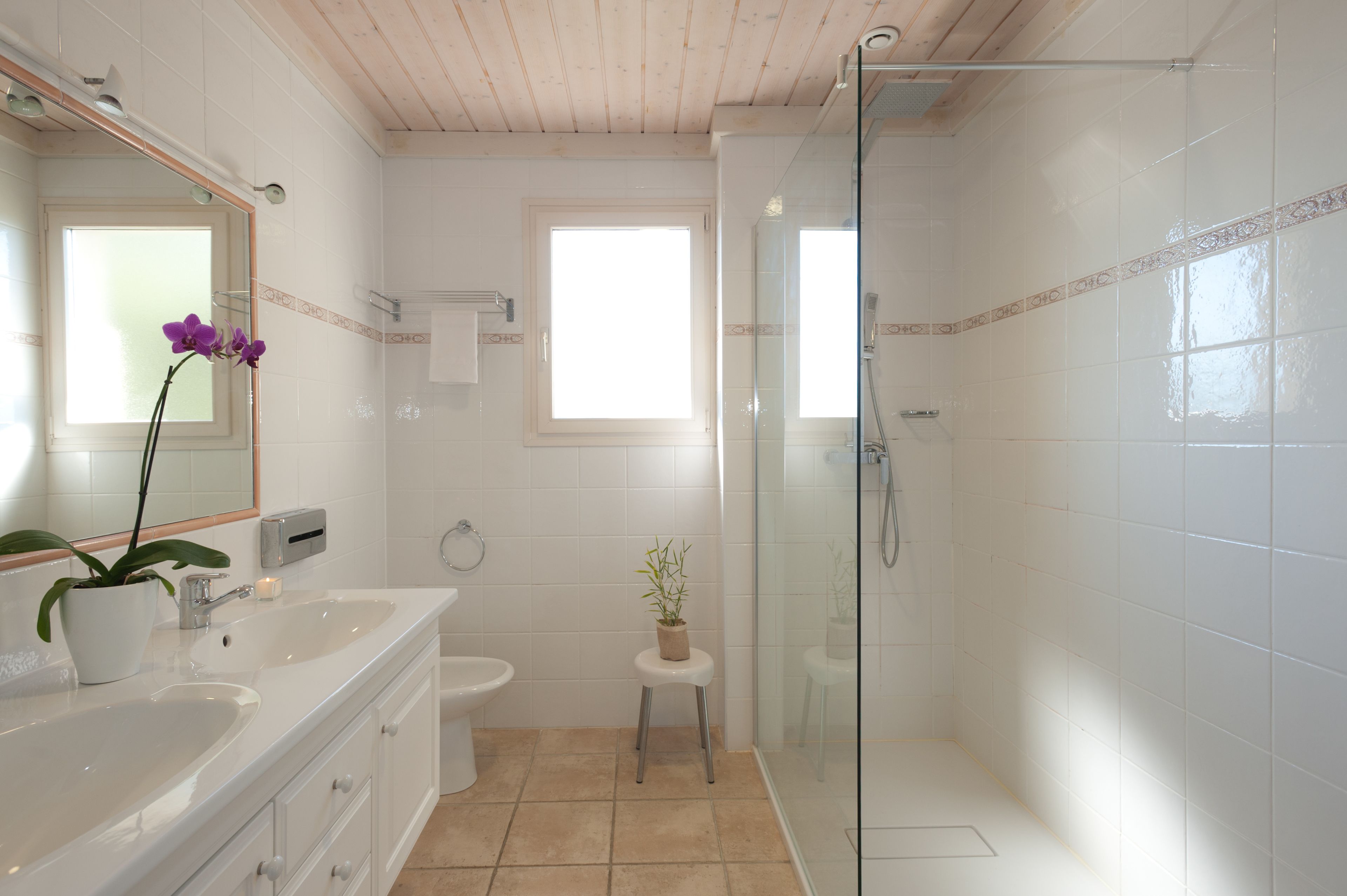 A modern bathroom with a glass shower, a sink, and a toilet.