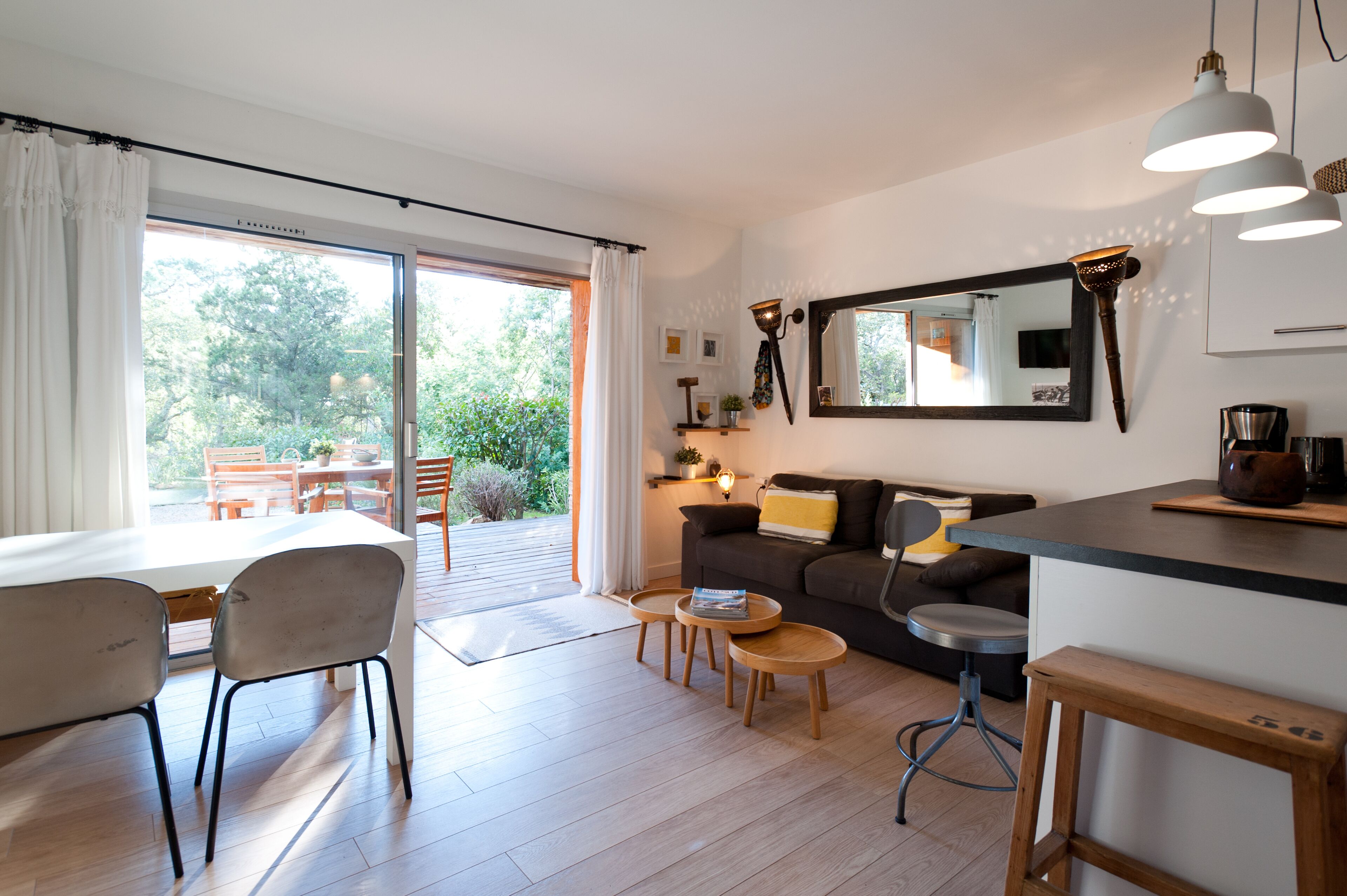 A modern living room with a sofa, coffee table, and dining area.
