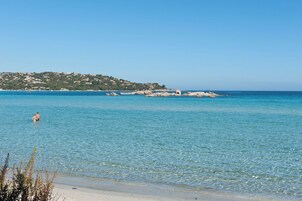 On the beach, white sand, sun loungers, beach umbrellas
