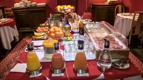Una mesa de buffet con diversos alimentos, como frutas, huevos y salsas.