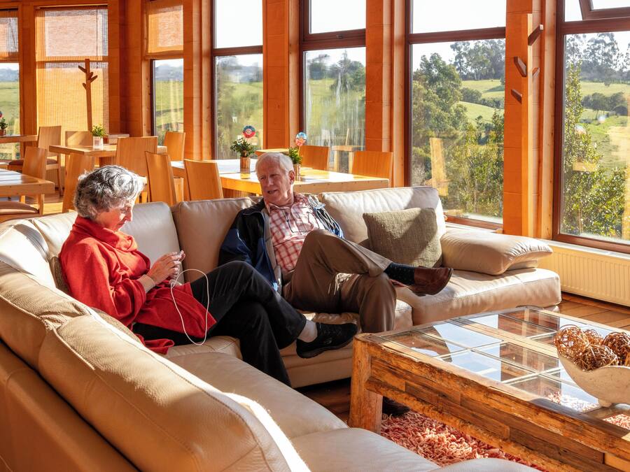 Una sala de estar acogedora con un ventanal que ofrece vistas a un paisaje verde.