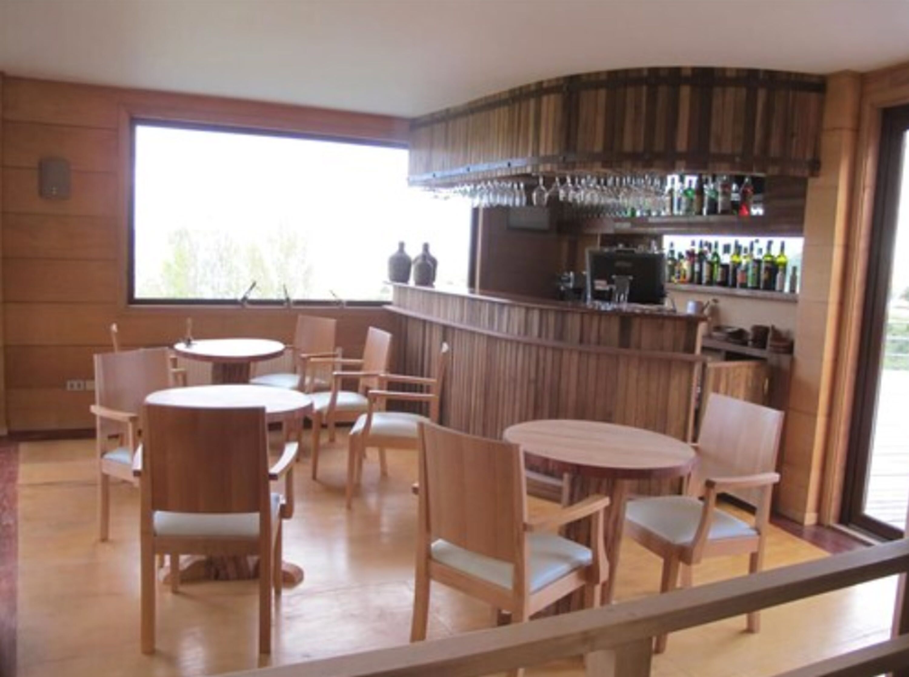 A bar area with wooden furniture and a large window.