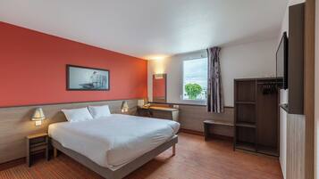 A hotel room with a bed, bedside tables, a desk, a chair, a wardrobe, a window with curtains, and a painting on the wall.