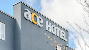 Un edificio con un cartel en la fachada que dice 'ace HOTEL'.