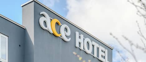 Un edificio con un cartel en la fachada que dice 'ace HOTEL'.