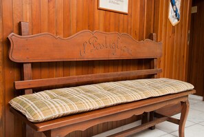 A wooden bench with a cushion and a sign above it that reads "il Postiglione." - Hotel Del Postiglione (Ischia)
